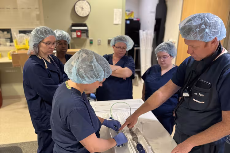 GRCC cardiovascular technology students dressed in scrubs learn about medical equipment.