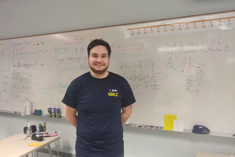 GRCC math instructor Chance Colter stands in front a white board in a classroom.