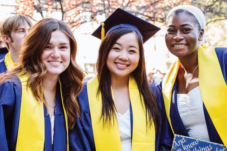 Three students pose in GRCC caps and gowns.