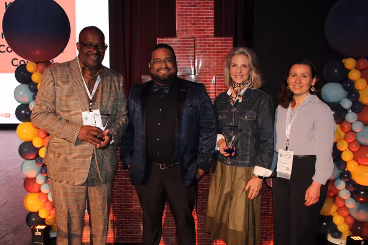 Recipients of the award pose at an event.