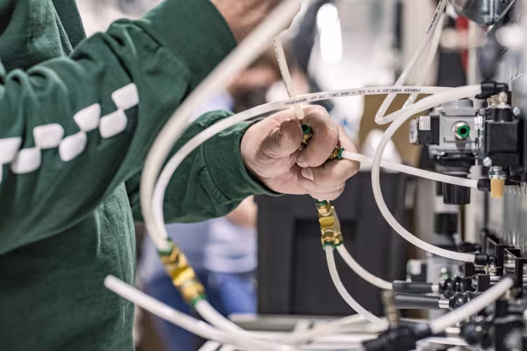 A person works with tubing attached to a machine.