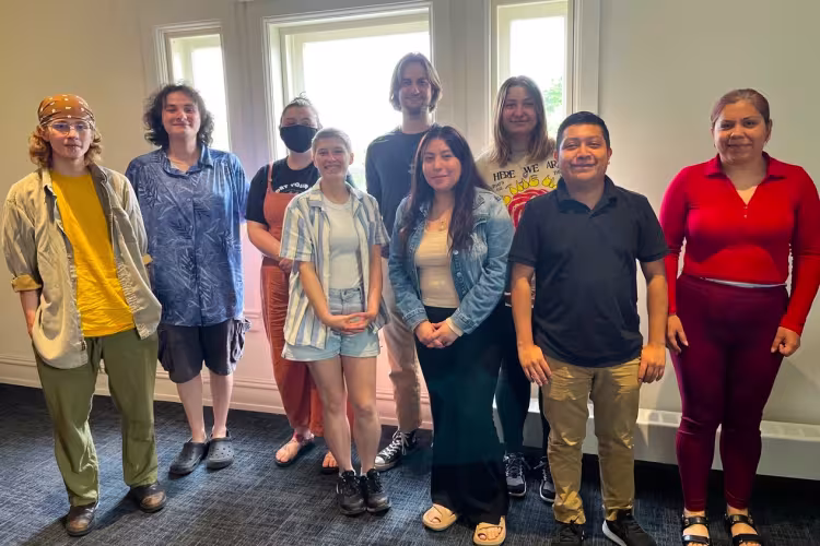 Nine people pose for a photo.
