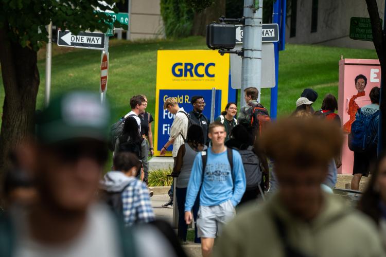 Students at GRCC cross the street in a crowd.