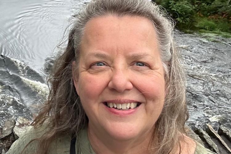 Humanities professor Tamera Detrick poses outdoors.