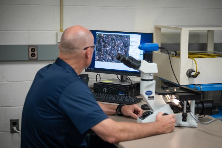 A quality science student uses equipment in a lab setting.