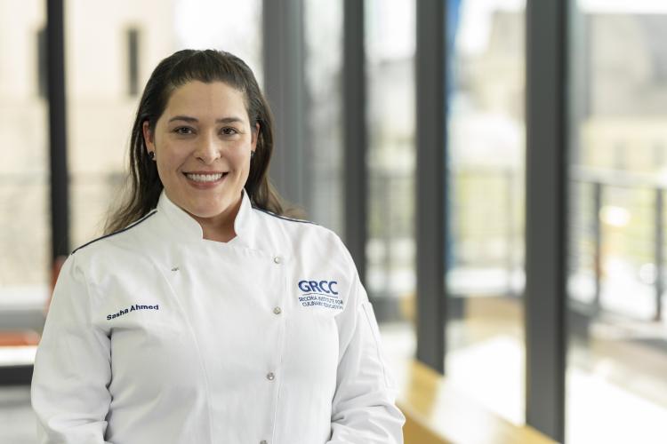 Associate professor Sasha Ahmed in a white chef coat.