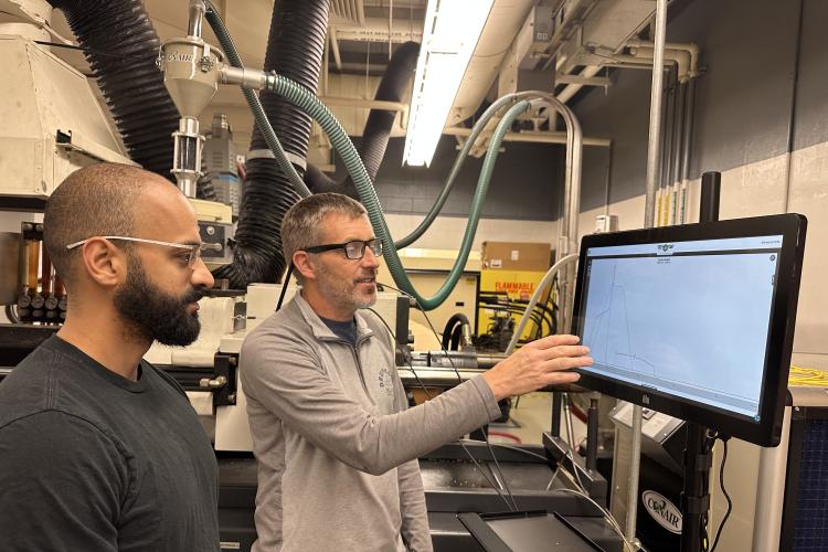 Assistant professor Scott Van Hoven shows a student how to use new monitoring technology in the plastics lab.
