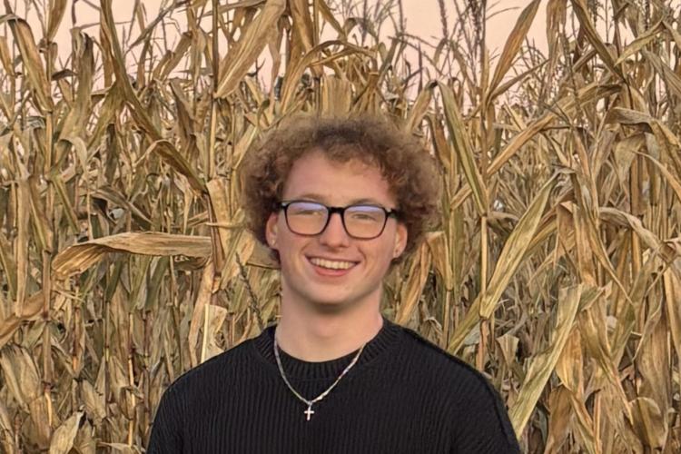 Tyler Watkins standing outside and smiling.