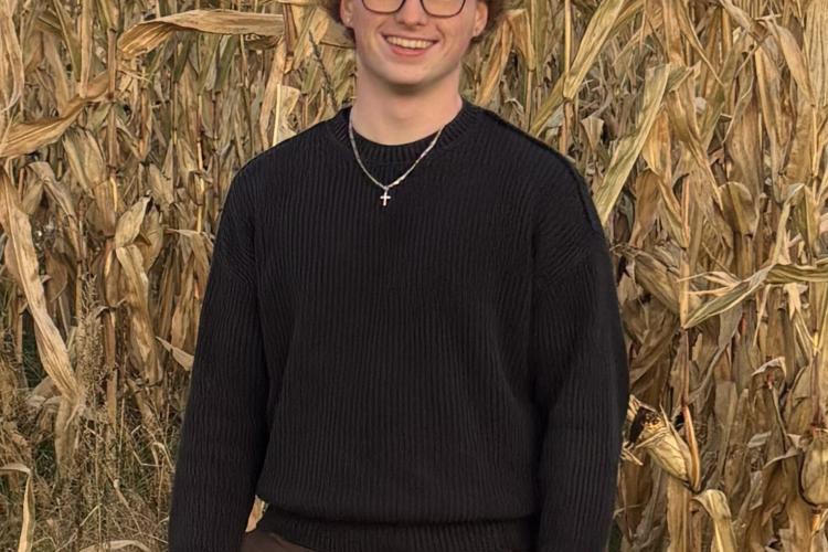 Tyler Watkins standing outside and smiling.