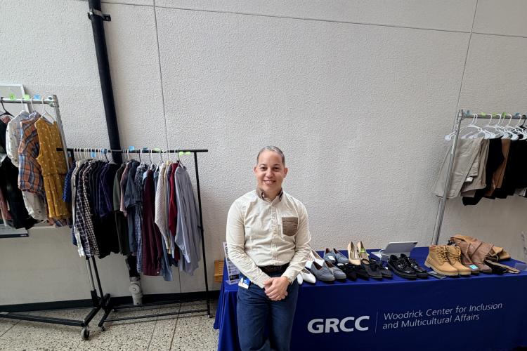 Joel Reyes Hernandez stands beside the student clothing pop-up.