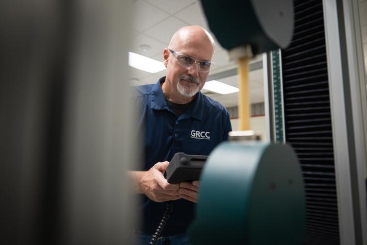 Chris McDonald, a professor in the Quality Science program, works with equipment in a lab.
