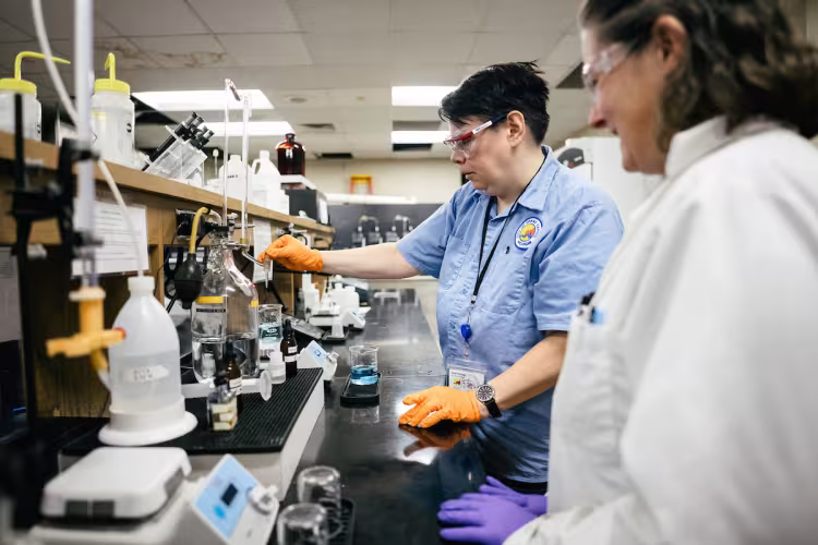 An intern at the City of Grand Rapids tests water in a lab.