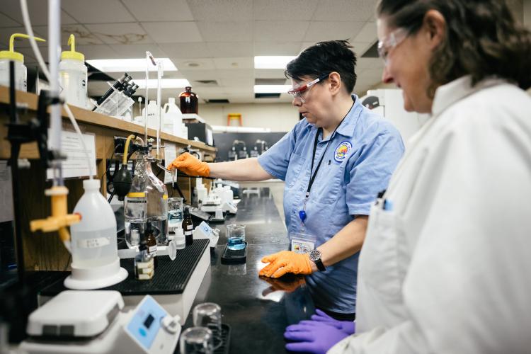 An intern at the City of Grand Rapids tests water in a lab.