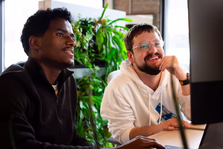 Mussie works with a Tech Collaborative employee at a computer.