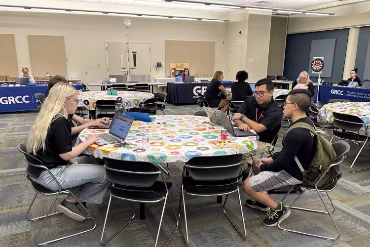 TRIO team members sit at a round table during a resource fair.