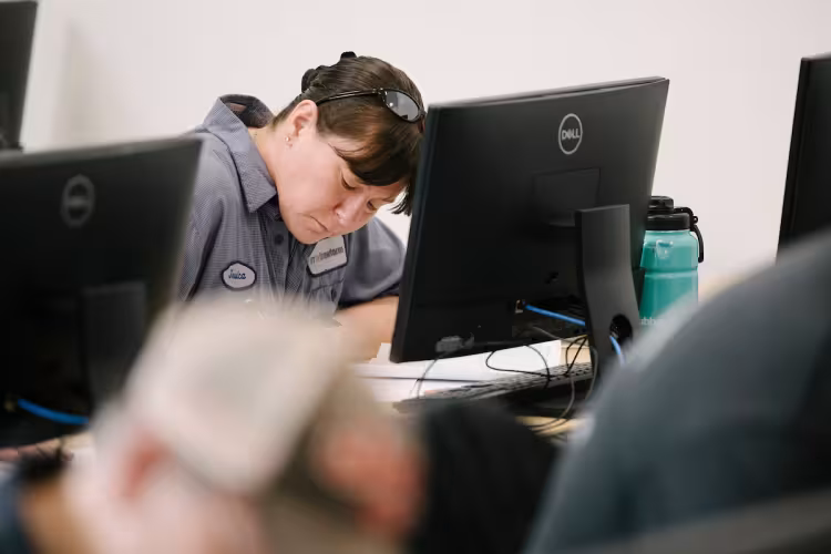 A student sits behind a computer in class.