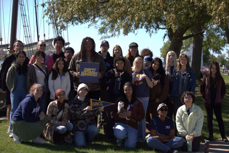 A group of GRCC students with a tall sailing ship in the background.
