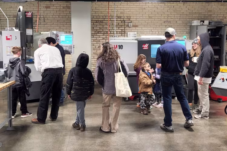 Families looking at manufacturing equipment at the 2022 event.