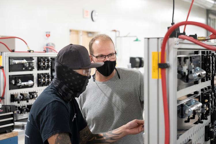 Ben Meyering teaching a student in a manufacturing lab.