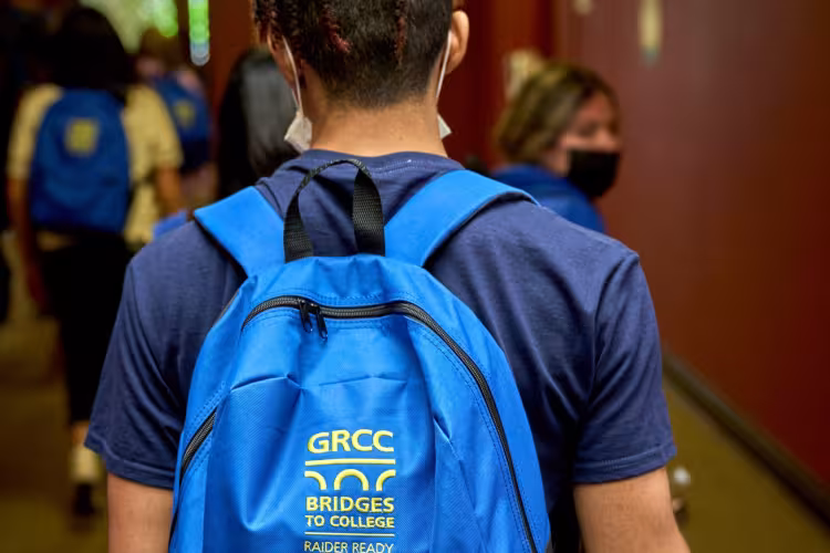 A Bridges to College student showing off his backpack.