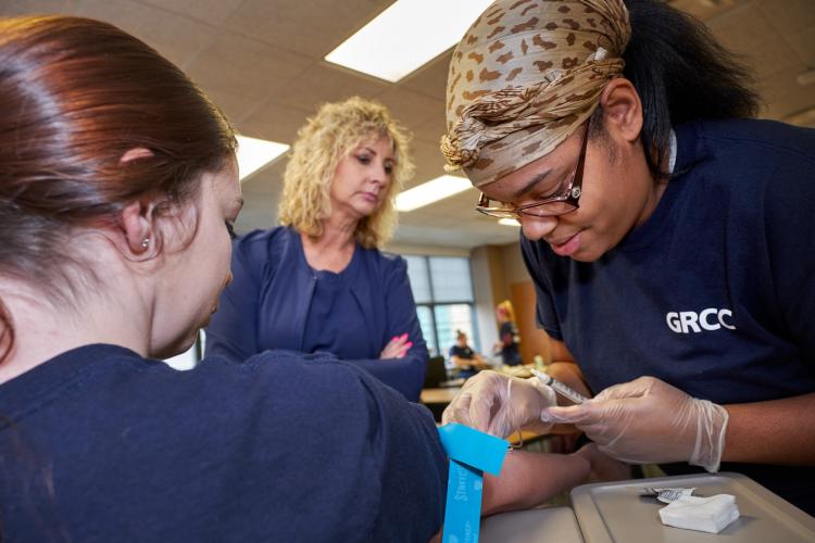 Students in a GRCC phlebotomy class learning how to draw blood.