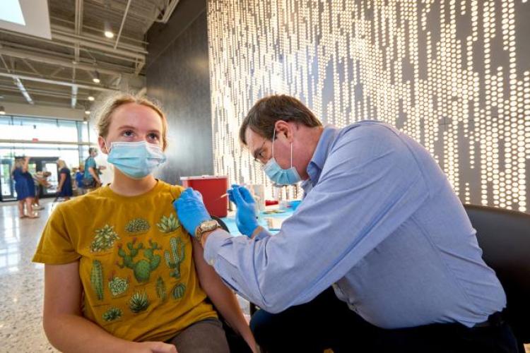 A GRCC Lakeshore Campus student taking getting a COVID vaccine shot.