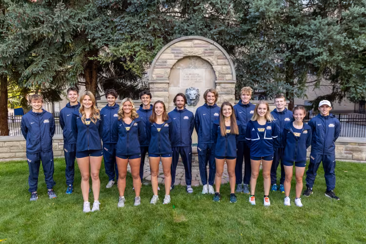 Cross country teams posing together at GRCC's iconic lion fountain. 