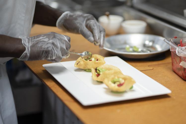 A close up of a Secchia student preparing a meal.