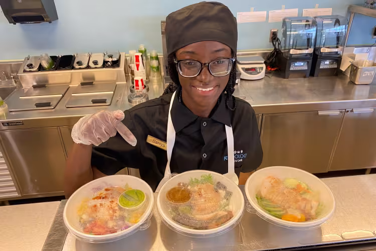 A Secchia Institute students points out healthier options in Foodology.