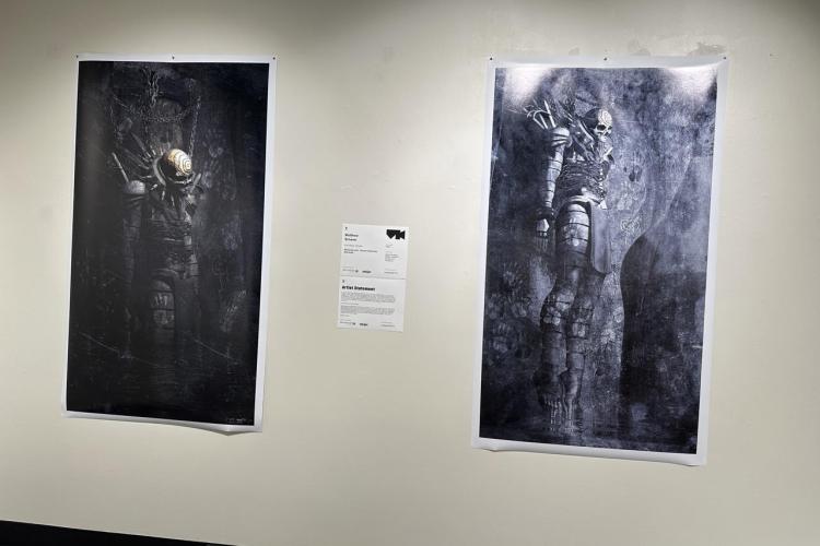 Two artpieces depicting skeletons in armor hang on a wall. 