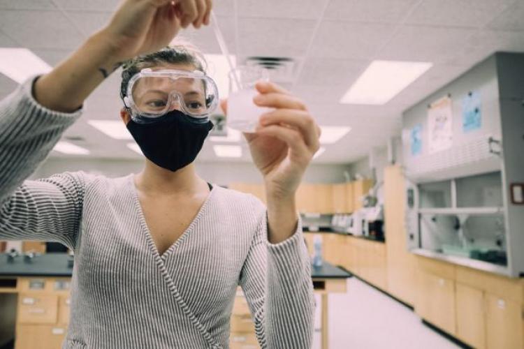 Chemistry student stirring contents of a beaker 