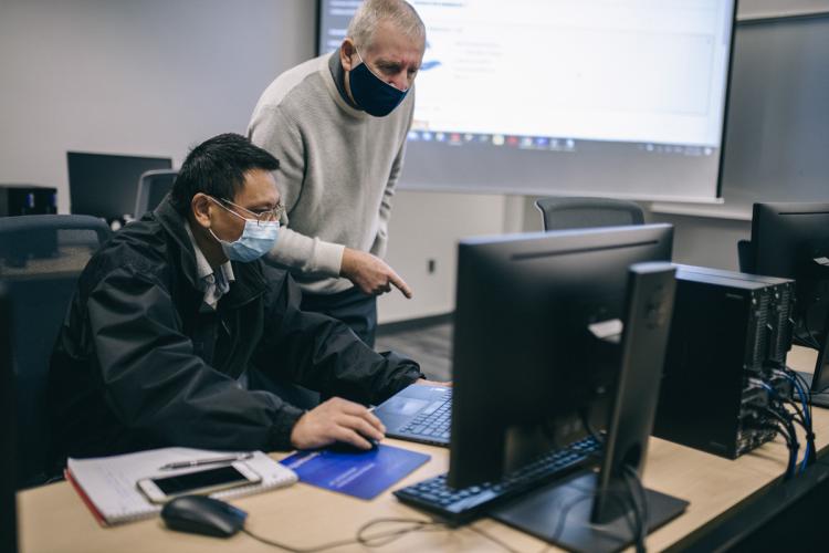 Student working with a professor in a GRCC CIS class.