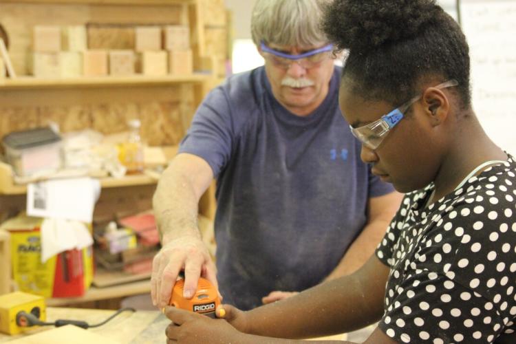 Instructor Steve Ray working with a student in woodworking camp.