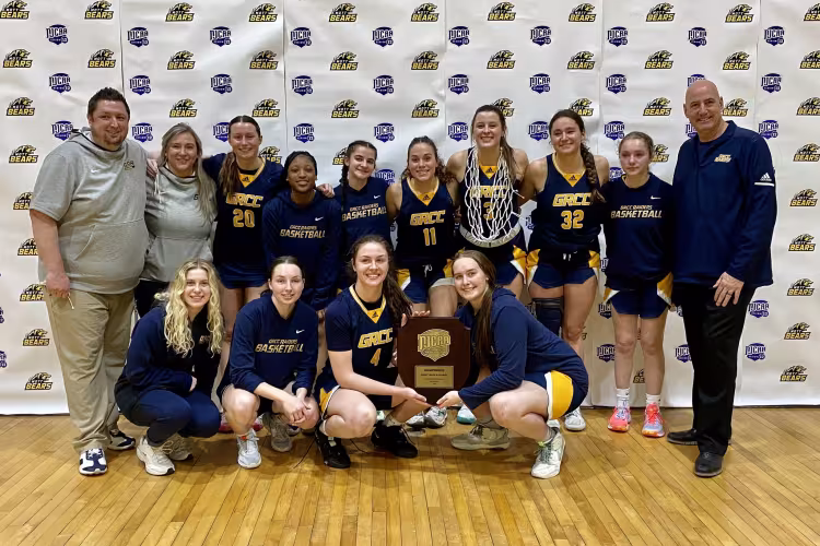 Team photo of the basketball players with their trophy.
