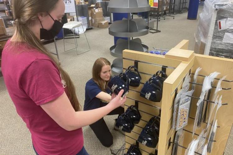 Bookstore employees stocking displays. 