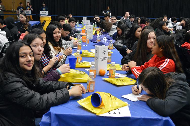 Students attending the Latino Youth Conference sitting around a table.