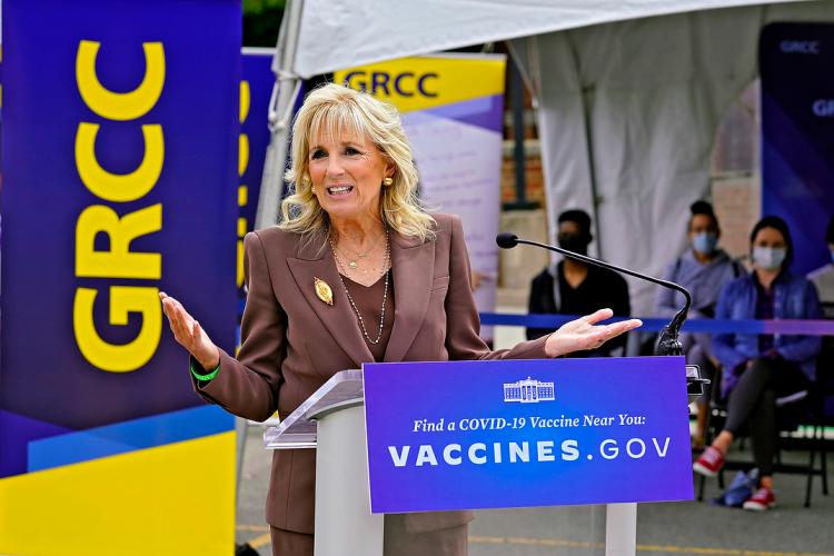 First Lady Jill Biden speaking at a podium after touring GRCC's pop-up clinic.