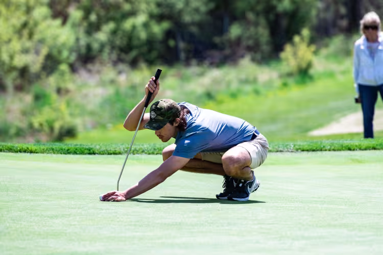 GRCC golfer lining up a putt on the green. 