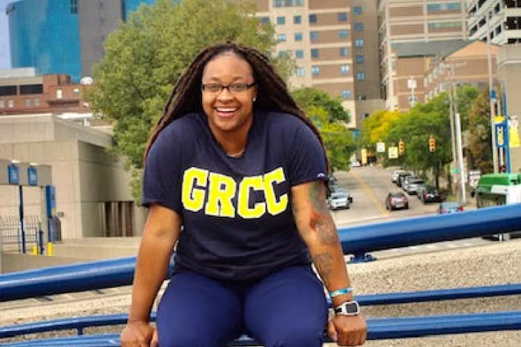 Portrait of Jamillya Hardley sitting on a fence on campus.