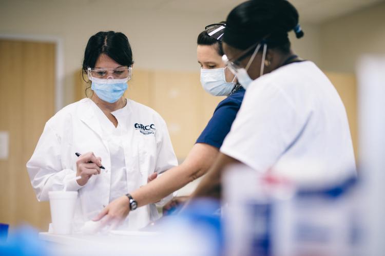 Three people in a GRCC nursing lab