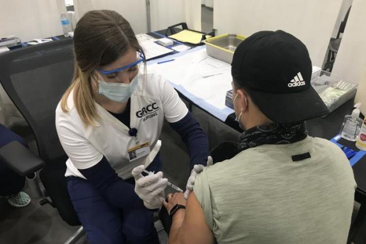 GRCC Nursing student administers vaccination at DeVos Place.