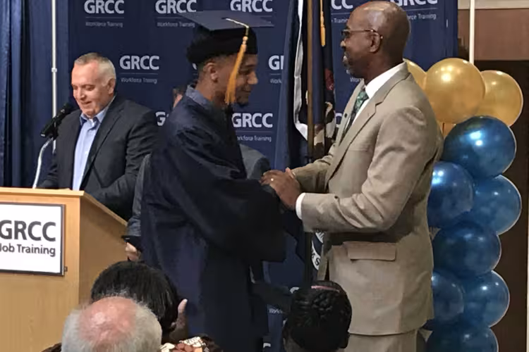 President Bill Pink shakes the hand of a Job Training graduate.