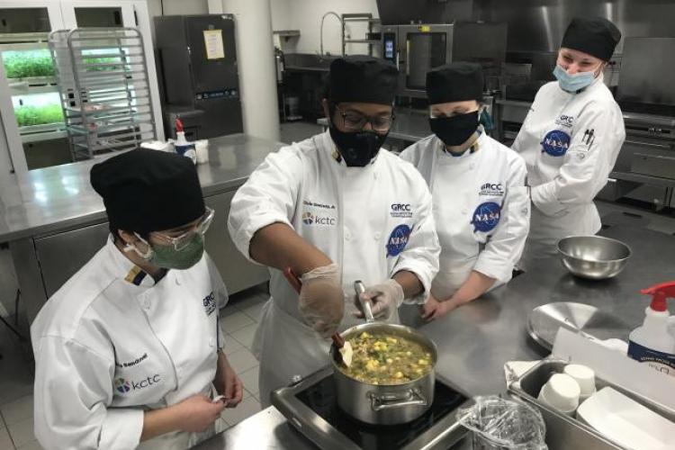 Students Olivia Sandoval, Chris Quezada, Elizabeth Afton and Grace Haaksma working in the Secchia kitchens.