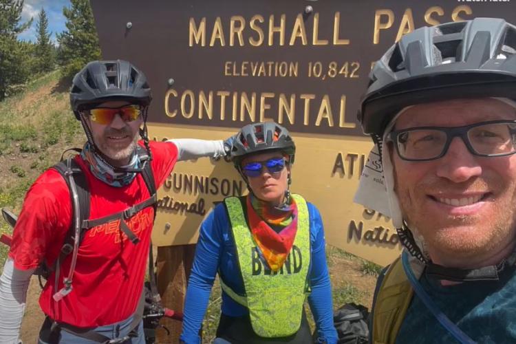 Jesse Crandall with Shawn Cheshire and Steve Martin posing with a sign on one of their trips.
