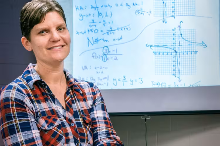 Jodi Dawson, standing in front of a screen with a math problem projected on it.