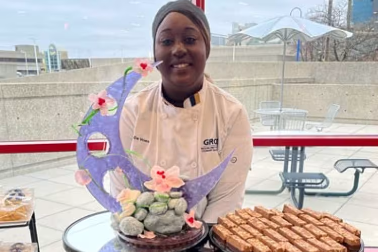 Culinary student Kat DeVries standing behind some of her pastries.