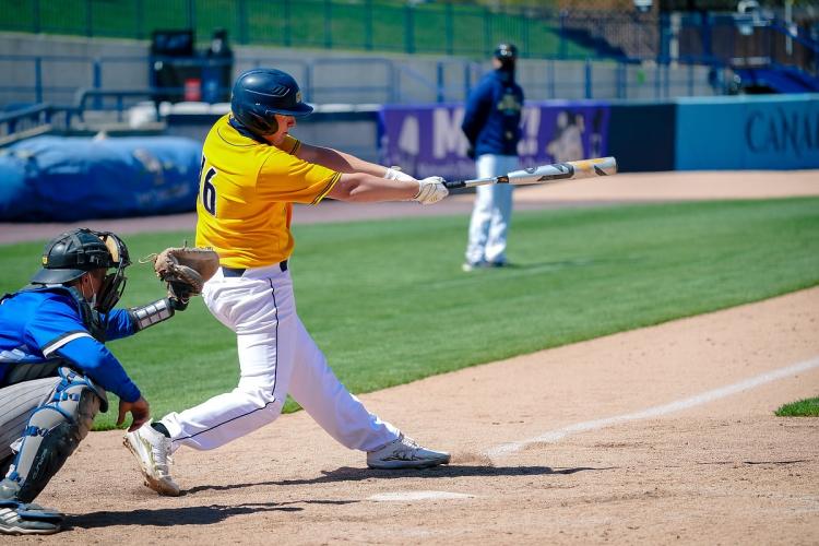 GRCC baseball player swinging at a pitch.