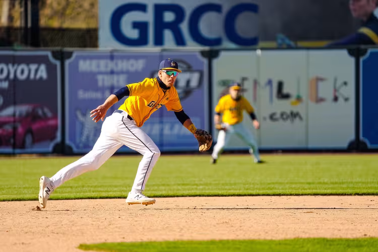 GRCC baseball players fielding at LMCU Ballpark.
