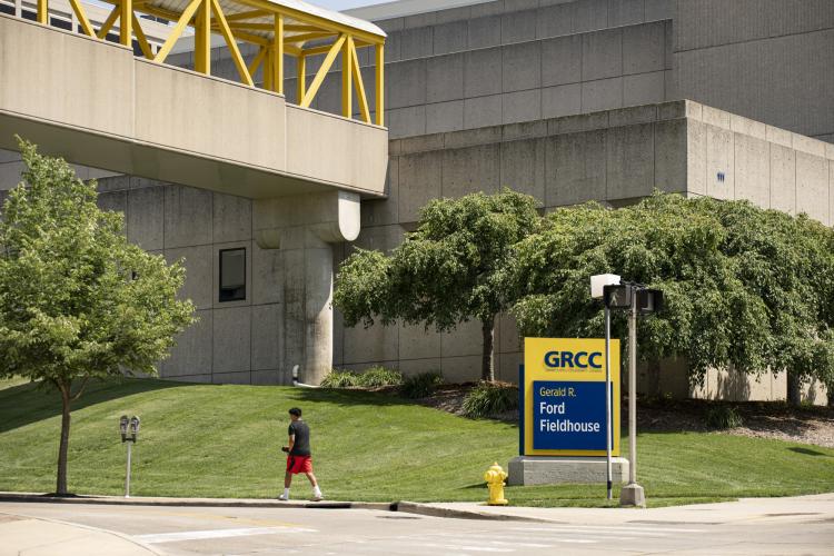 A person walks past a GRCC sign on campus