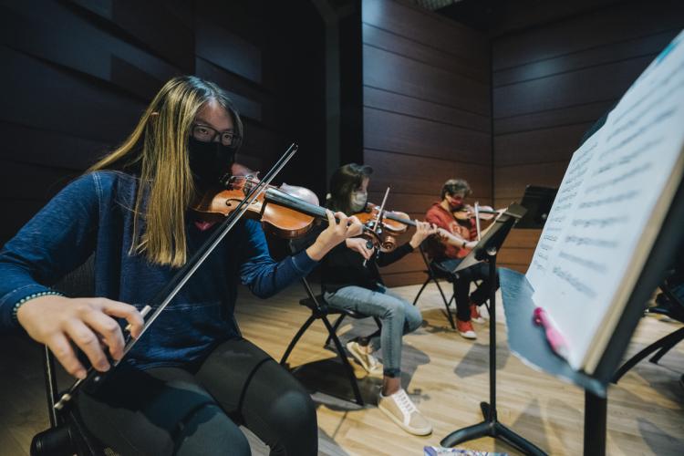 Music students playing string instruments.